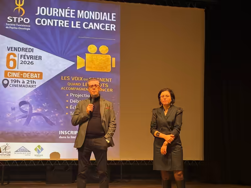 Échange avec le public devant l'écran de la Journée mondiale du cancer